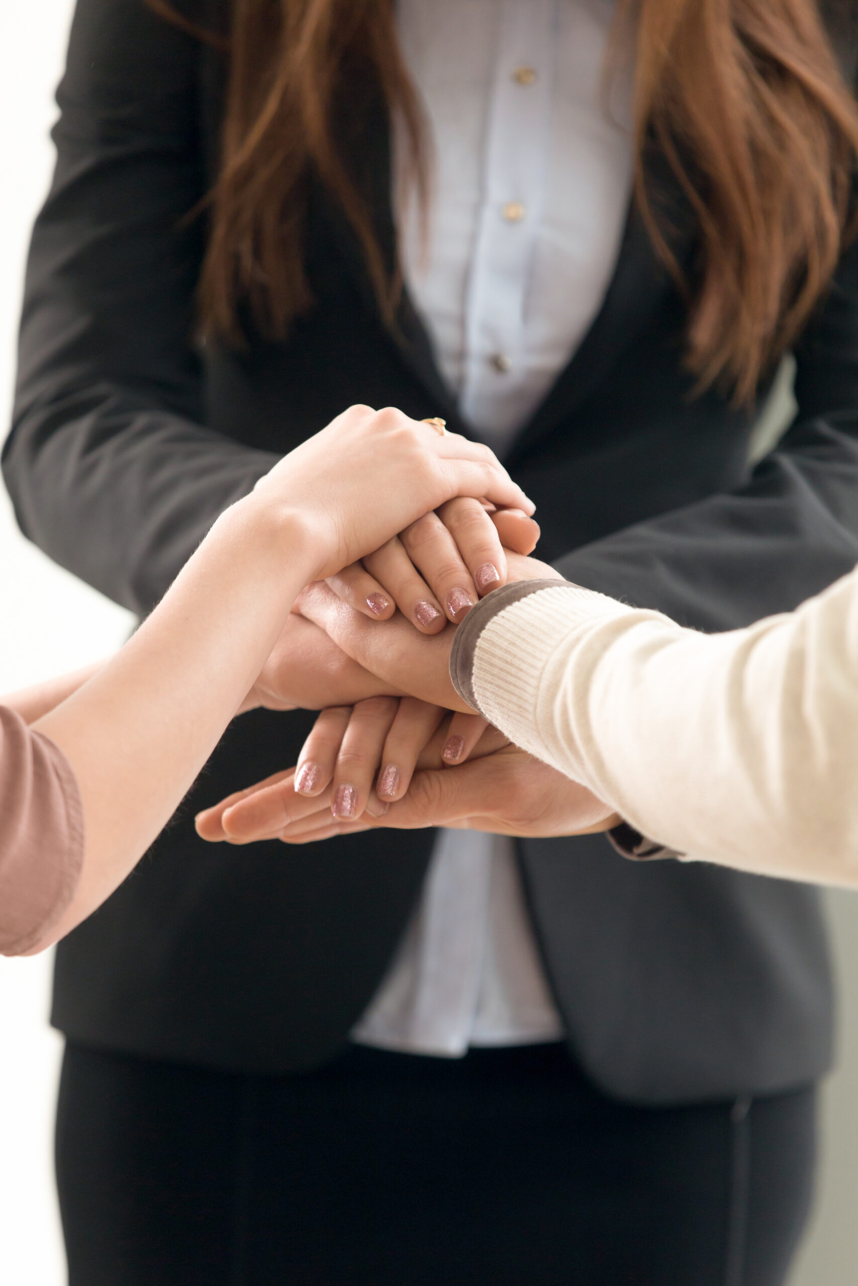 Team management concept, business people joining hands, vertical